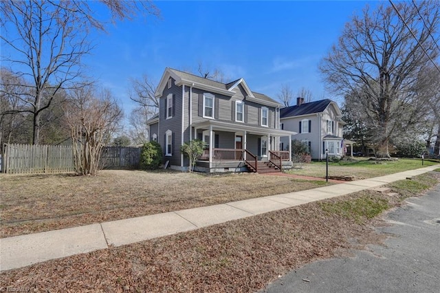 view of front of house featuring a porch, a front lawn, and fence