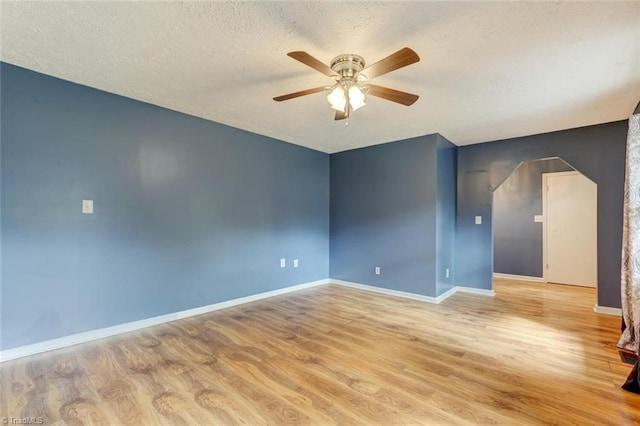 empty room featuring light hardwood / wood-style flooring, a textured ceiling, and ceiling fan