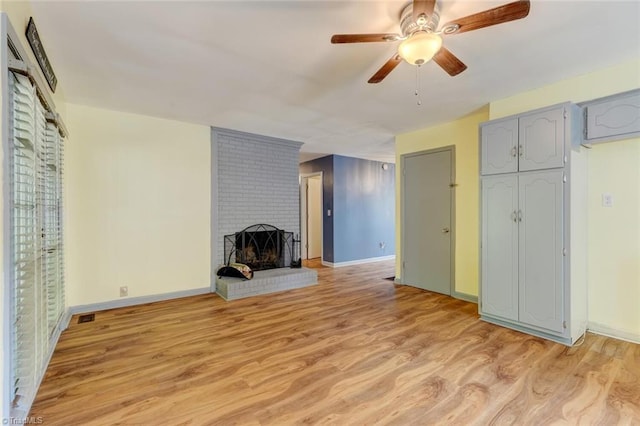 unfurnished living room featuring ceiling fan, a fireplace, and light hardwood / wood-style floors