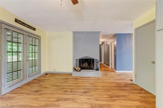 unfurnished living room featuring light hardwood / wood-style floors, a fireplace, and ceiling fan