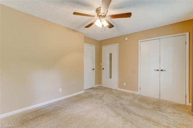 unfurnished bedroom with carpet floors, a textured ceiling, ceiling fan, and a closet