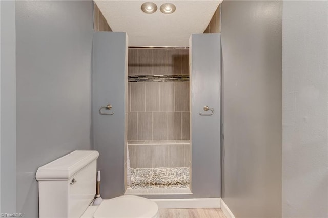 bathroom featuring walk in shower, wood-type flooring, and toilet