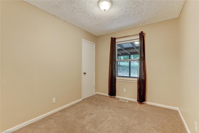 unfurnished room with light carpet and a textured ceiling