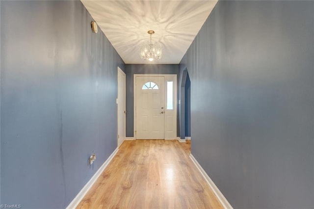 doorway featuring an inviting chandelier and light hardwood / wood-style flooring