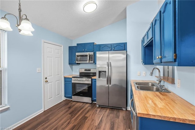 kitchen with lofted ceiling, blue cabinetry, dark wood-style flooring, a sink, and appliances with stainless steel finishes