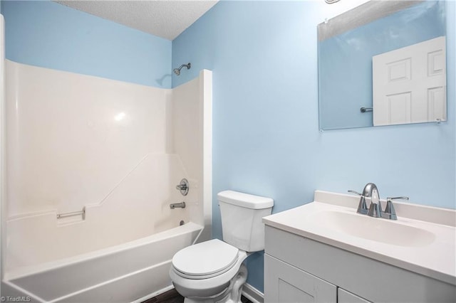 bathroom with a textured ceiling, toilet, vanity, and  shower combination