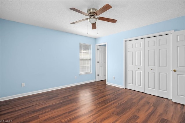 unfurnished bedroom with baseboards, dark wood finished floors, a closet, a textured ceiling, and a ceiling fan