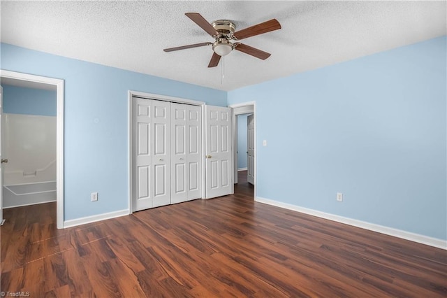 unfurnished bedroom featuring wood finished floors, baseboards, a closet, and a textured ceiling