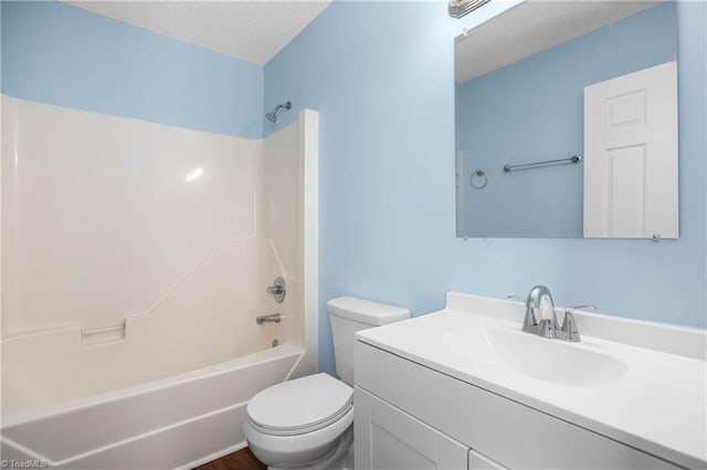 bathroom with vanity, toilet, tub / shower combination, and a textured ceiling