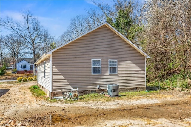 view of side of home with central AC unit and crawl space