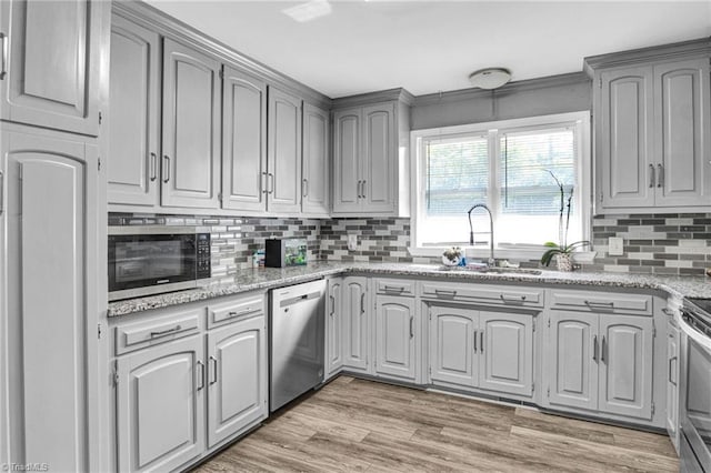 kitchen with gray cabinetry, decorative backsplash, sink, and appliances with stainless steel finishes