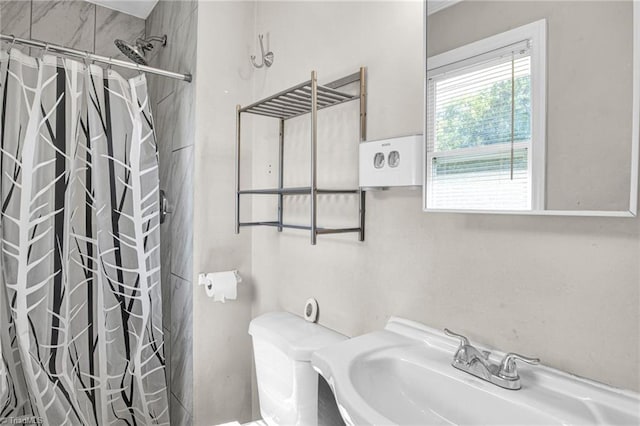 bathroom featuring sink, a shower with shower curtain, and toilet