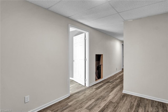 hallway with hardwood / wood-style floors and a drop ceiling