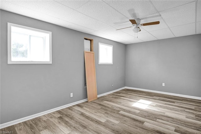 spare room featuring a paneled ceiling, ceiling fan, and light hardwood / wood-style floors