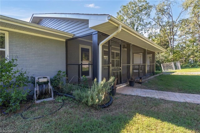 view of home's exterior featuring a lawn and a sunroom