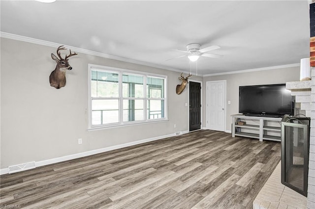 unfurnished living room with a brick fireplace, ceiling fan, hardwood / wood-style floors, and ornamental molding