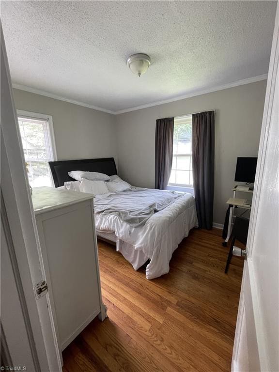 2820 Shady Lawn Dr, Greensboro, NC 27408 - bedroom with wood finished floors, a textured ceiling, and crown molding