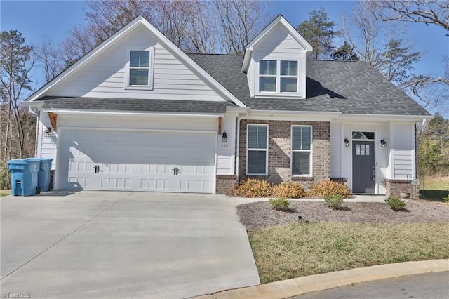 view of front facade with brick siding, driveway, a garage, and roof with shingles