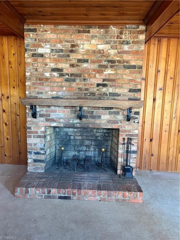 room details with carpet floors, a fireplace, wood ceiling, and wooden walls