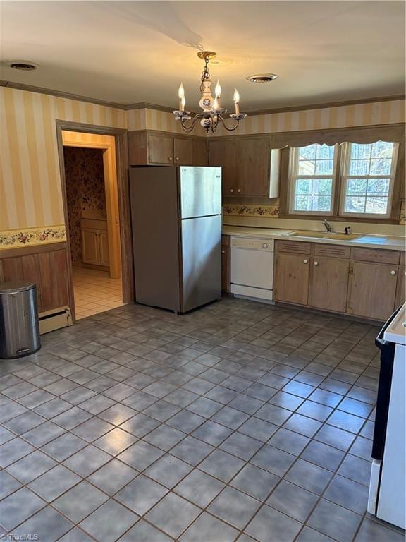 kitchen featuring a baseboard radiator, pendant lighting, white dishwasher, a notable chandelier, and stainless steel refrigerator