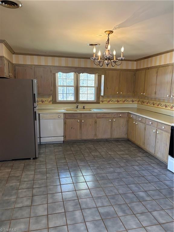 kitchen with dishwasher, sink, an inviting chandelier, pendant lighting, and stainless steel fridge