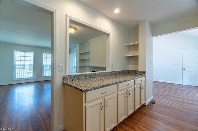 kitchen with dark hardwood / wood-style floors and dark stone counters