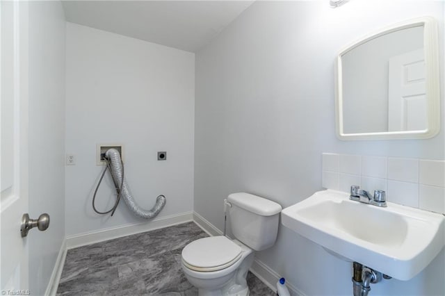 bathroom featuring tile patterned flooring, toilet, decorative backsplash, and sink