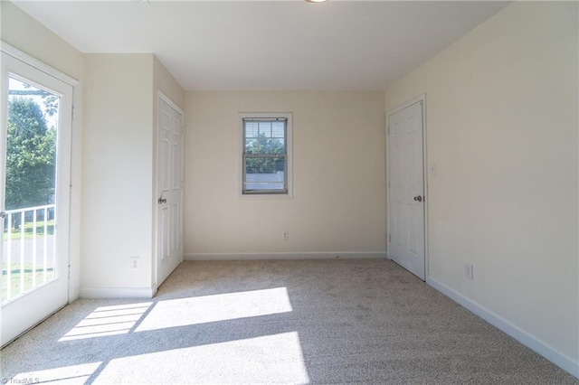 spare room featuring light carpet and a healthy amount of sunlight