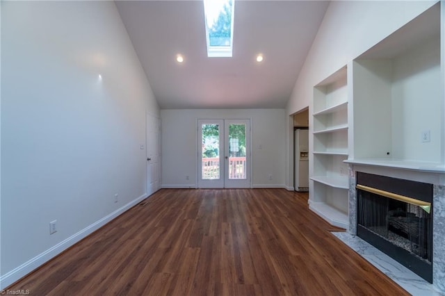 unfurnished living room with high vaulted ceiling, dark hardwood / wood-style flooring, a skylight, french doors, and a premium fireplace