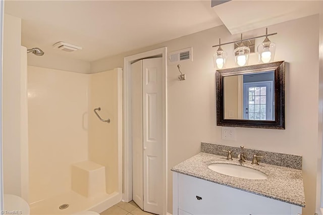 bathroom with walk in shower, tile patterned floors, and vanity