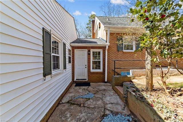 doorway to property featuring brick siding