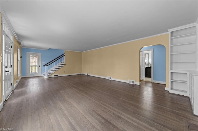 unfurnished living room with arched walkways, dark wood-type flooring, stairway, and visible vents