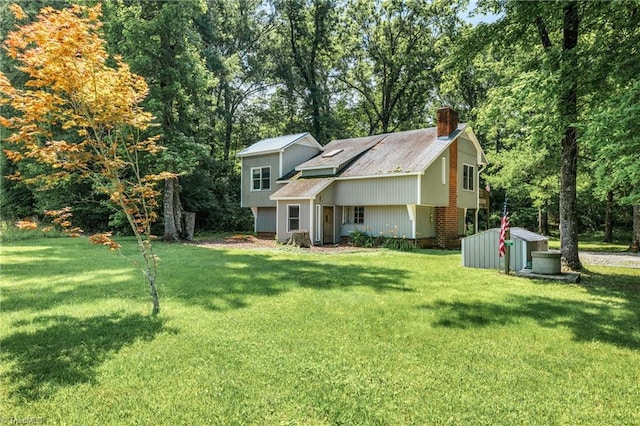 3542 Wayne White Rd, Climax, NC 27233 - view of front of home with a storage shed, a chimney, a front lawn, and view of scattered trees