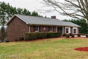 single story home with a front yard and a chimney