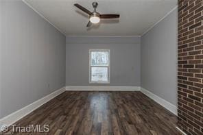 empty room with ornamental molding, ceiling fan, wood finished floors, and baseboards