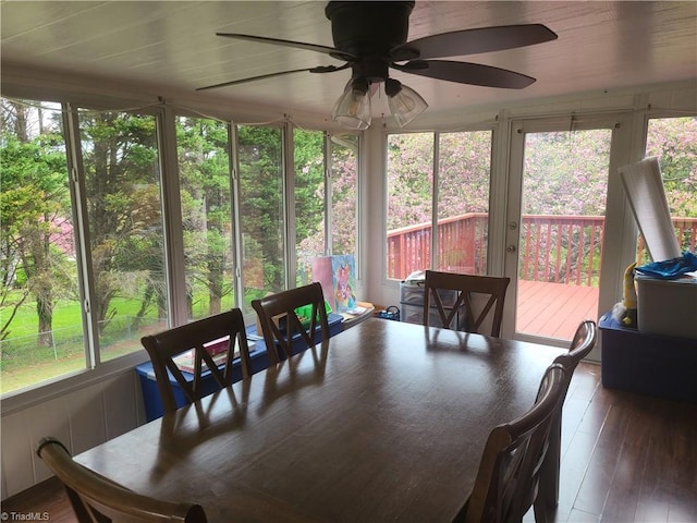 sunroom / solarium with hardwood / wood-style floors, a healthy amount of sunlight, and a deck