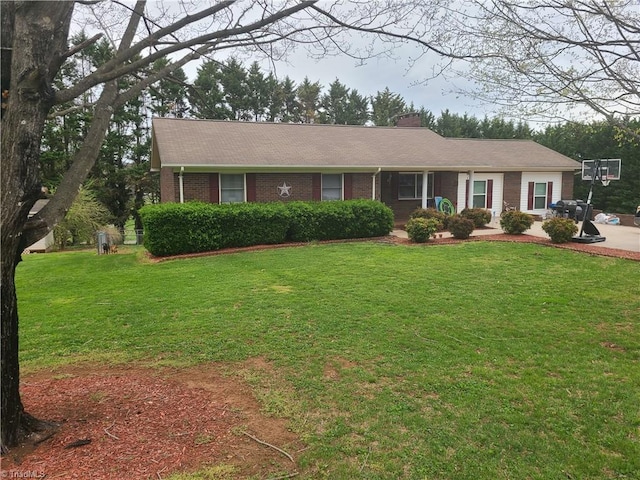 ranch-style house with brick siding, a front lawn, and a chimney