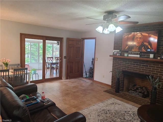 living area featuring ceiling fan, a fireplace, a textured ceiling, light tile patterned flooring, and baseboards