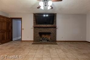 unfurnished living room featuring tile patterned floors, ceiling fan, a brick fireplace, and baseboards
