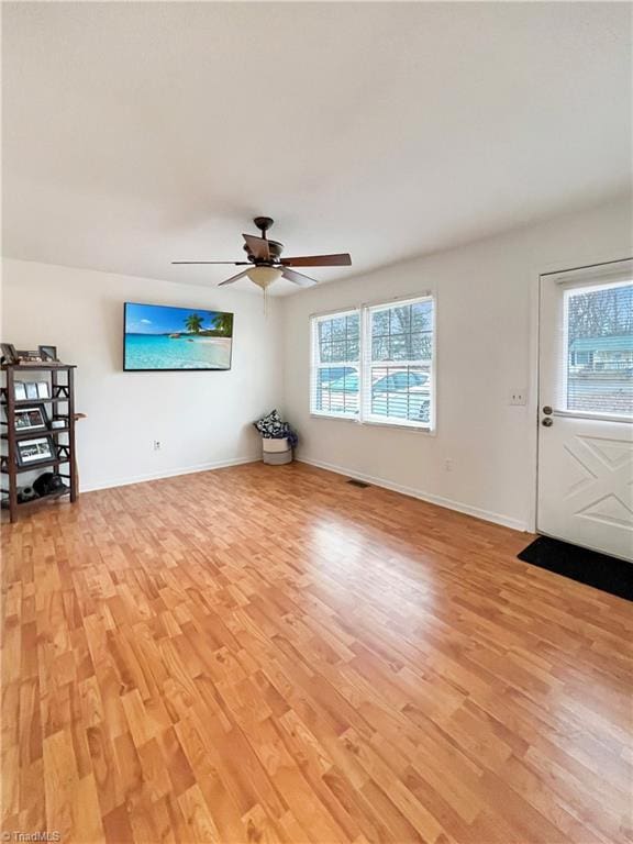 unfurnished living room featuring ceiling fan and light wood-type flooring