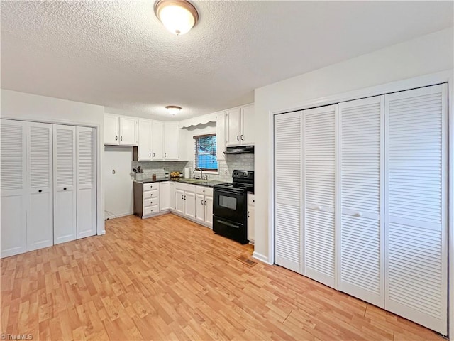 kitchen with sink, white cabinets, backsplash, and black range with electric cooktop