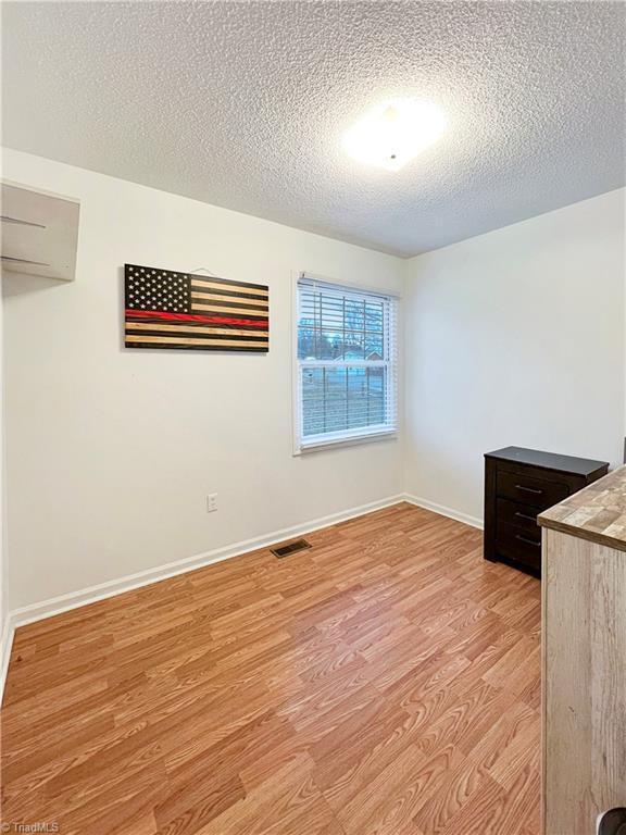 interior space with light hardwood / wood-style floors and a textured ceiling