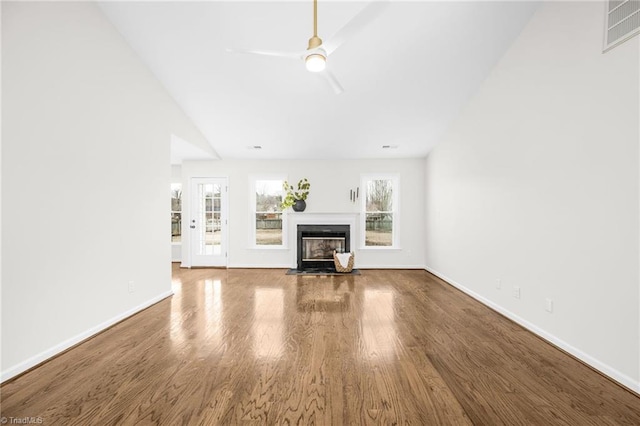 unfurnished living room with ceiling fan, wood-type flooring, and vaulted ceiling