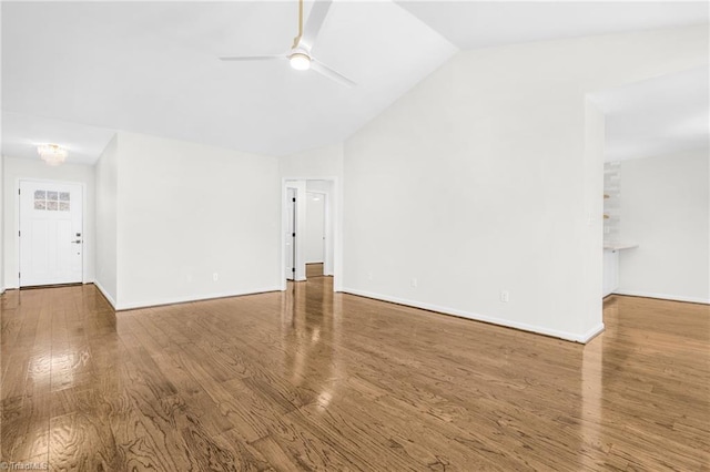 empty room with ceiling fan, wood-type flooring, and vaulted ceiling