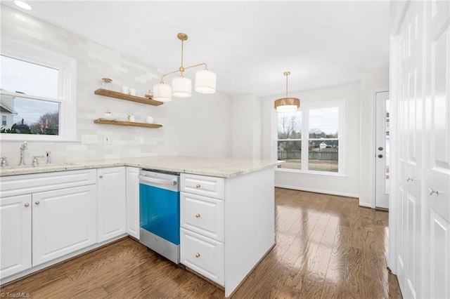 kitchen with white cabinetry, stainless steel dishwasher, kitchen peninsula, and sink