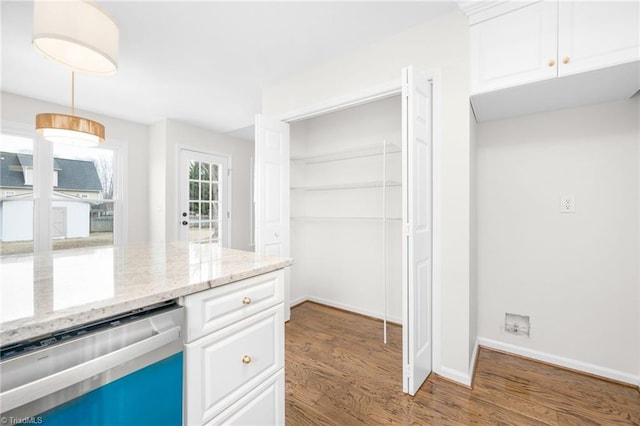 kitchen featuring decorative light fixtures, dark hardwood / wood-style floors, dishwasher, light stone countertops, and white cabinets