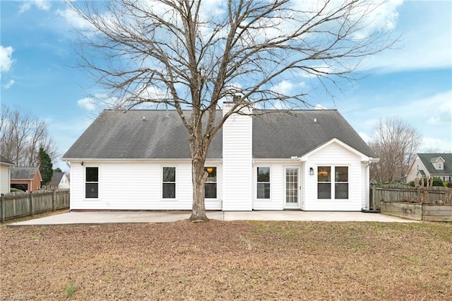 back of property with a yard and a patio