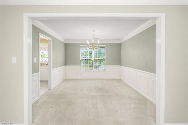 131 Hickory Creek Ct, Winston-Salem, NC 27107 - unfurnished dining area with a chandelier, ornamental molding, a wainscoted wall, light carpet, and a decorative wall