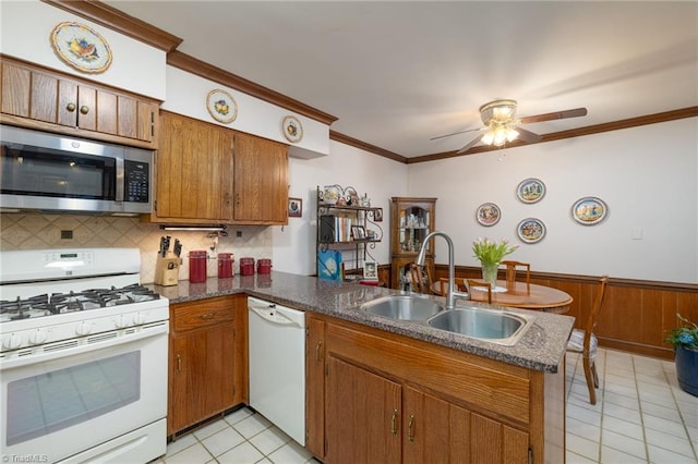 kitchen with sink, crown molding, white appliances, light tile patterned floors, and kitchen peninsula