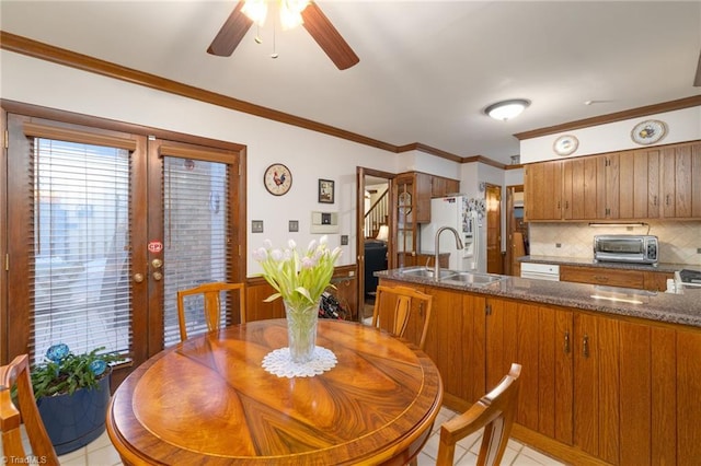 tiled dining room featuring sink, crown molding, french doors, and ceiling fan